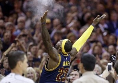 Cleveland Cavaliers' LeBron James tosses chalk in the air before the start of an NBA basketball game against the New York Knicks Thursday, Oct. 30, 2014, in Cleveland. (AP Photo/Tony Dejak)