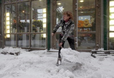 FILE - A florist shovels snow away from infront of her shop during snowfall in St.Petersburg, Russia, 30 November 2012. The temperature in St. Petersburg dropped to minus eight degrees Celsius. Photo: EPA/ANATOLY MALTSEV (zu dpa «Einwohner von St. Petersburg sollen selbst Schnee schippen» vom 15.01.2015) +++(c) dpa - Bildfunk+++