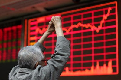 A stock investor reacts in front of an electronic screen