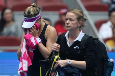Eugenie Bouchard (L) of Canada receives medical treatment