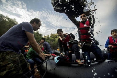 epa04965922 Refugees traveling by overloaded rubber dinghy from Turkey arrive at the coast near Mytilene, Lesbos,