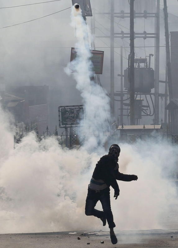 epa05003177 A Kashmiri Muslim protester throws a tear gas canister during a protest in downtown Srinagar, the summer capital of Indian Kashmir, 30 October 2015. According to media reports, Indian police officers and paramilitary soldiers resorted to throwing tear gas and firing rubber bullets in order to disperse demonstrators who were protesting against the killing of Lashkar-e-Toiba militant commander Abu Qasim, after Friday prayers outside the Jamia Masjid main mosque. EPA/FAROOQ KHAN +++(c) dpa - Bildfunk+++