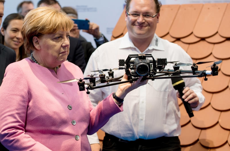 Bundeskanzlerin Angela Merkel (CDU) schaut sich am 26.02.2016 in München (Bayern) nach dem Münchener Spitzengespräch der deutschen Wirtschaft an einem Messestand des deutschen Dachdecker-Verbandes eine Drohne an. Foto: Sven Hoppe/dpa +++(c) dpa - Bildfunk+++