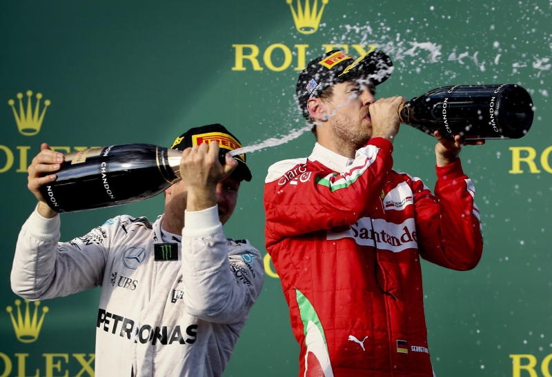 German Formula One driver Sebastian Vettel (R) of Scuderia Ferrari pours champagne over Australian former Formula One driver Mark Webber (2-R) next to winner German Formula One driver Nico Rosberg (2-L) of Mercedes AMG GP and British Formula One driver Lewis Hamilton of Mercedes AMG GP at the end of the