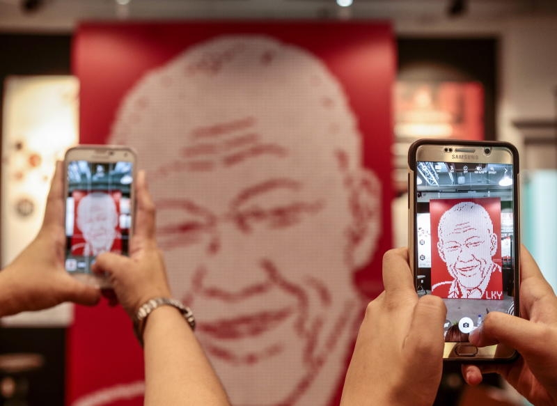 Visitors take photographs with their mobile phone of a mural made out of nearly 5,000 Singapore country erasers forming the likeness of Mr Lee Kuan Yew, during a tribute event in Singapore, 20 March 2016. The country's first prime minister, Mr Lee Kuan Yew, passed away last year on 23 March 2015. His passing was met with an outpouring of emotion and gratitude as over half a million Singaporeans lined up to pay their last respects to a man that many consider to be the founding father of Singapore. Lee was 91. EPA/WALLACE WOON +++(c) dpa - Bildfunk+++
