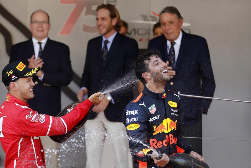 <p>Der deutsche Ferrari-Fahrer Sebastian Vettel (r) Teamkollegen Kimi Raikkönen aus Finnland jubeln auf der Bühne.</p>