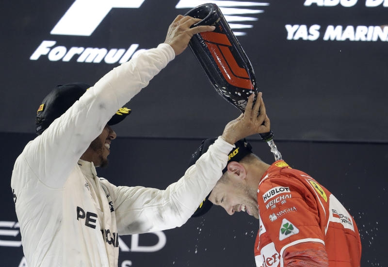 <p>Motorsport: Formel-1-Weltmeisterschaft, Grand Prix von Abu Dhabi, Rennen am 26.11.2017 in Abu Dhabi (Vereinigte Arabische Emirate): Die Mercedes-Piloten Lewis Hamilton (l, Großbritannien) und Valtteri Bottas (M, Finnland) feiern bei der Siegerehrung mit Ferrari-Pilot Sebastian Vettel (r, Deutschland). </p>