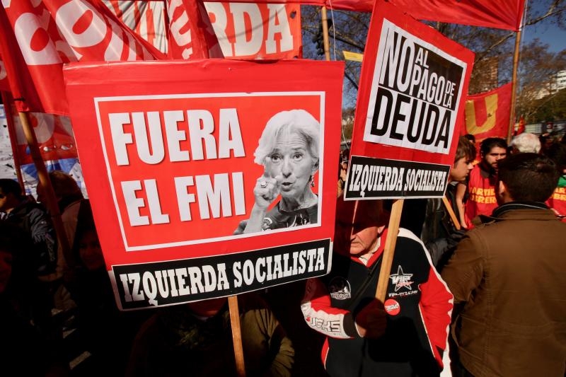<p>Argentinien, Buenos Aires: Demonstranten halten ein Plakat mit der Aufschrifft «Fuera el FMI. Izquierda Socialista»</p>